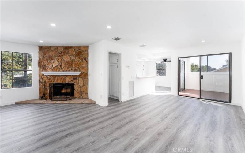 Spacious living room with stone fireplace leading to the private patio