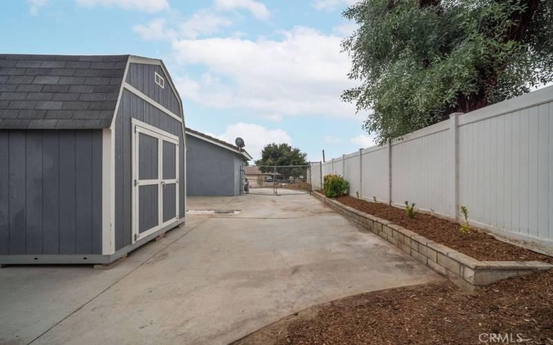 Side yard with RV hookups and Tuff Shed