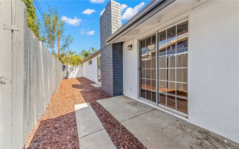 Sliding door leading to side yard. Can be set up with a small outdoor table and chairs with courtyard feel.