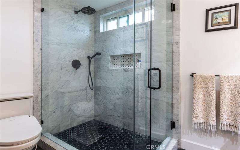 Large walk in shower with top of the line frameless door and marble