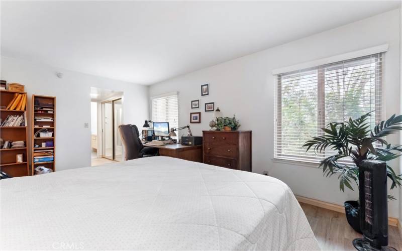 Another angle of the first of two spacious primary suites with two windows overlooking the hillside.