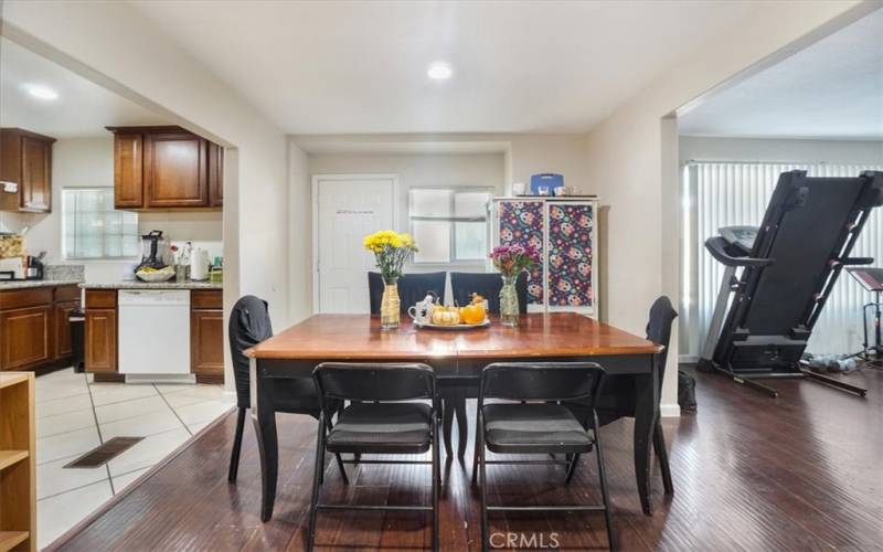 The dining room has recessed lighting and is between the living room and the kitchen.