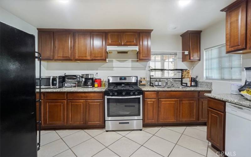 The remodeled kitchen is in the back of the home and has dark wood cabinets highlighted by a granite countertop and a stainless steel range.