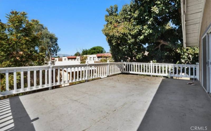 The balcony is surrounded by large trees for extra privacy.