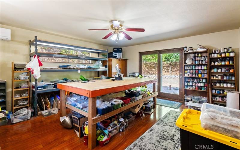 The primary bedroom, currently being used as an art studio, offers fantastic natural light and an atrium style door that leads out to the back patio.