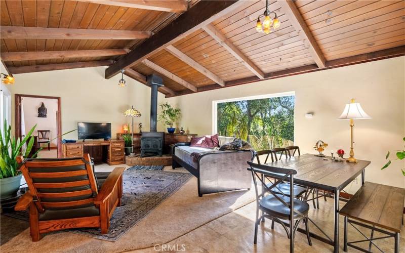 The living room is adjacent to the dining area and boasts cathedral wood beam ceilings.