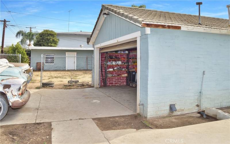 For some perspective, this shows the driveway and entrance to the smaller garage with a view of the next fenced yard and the larger garage beyond that.