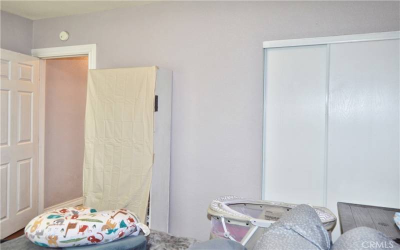 The primary bedroom looks out on the front yard and features more of that gorgeous wood laminate flooring and a modern ceiling fan light.