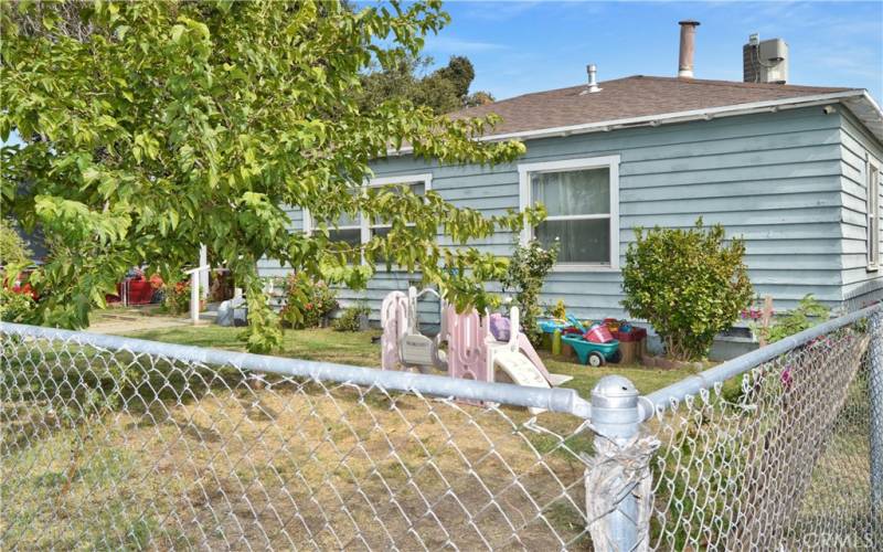 This charming home sits on a corner lot with a fenced and cross-fenced yard full of possibilities. The front yard has walkways from both gates, a grassy lawn, shade trees, roses, and more greenery to create an inviting space to play.