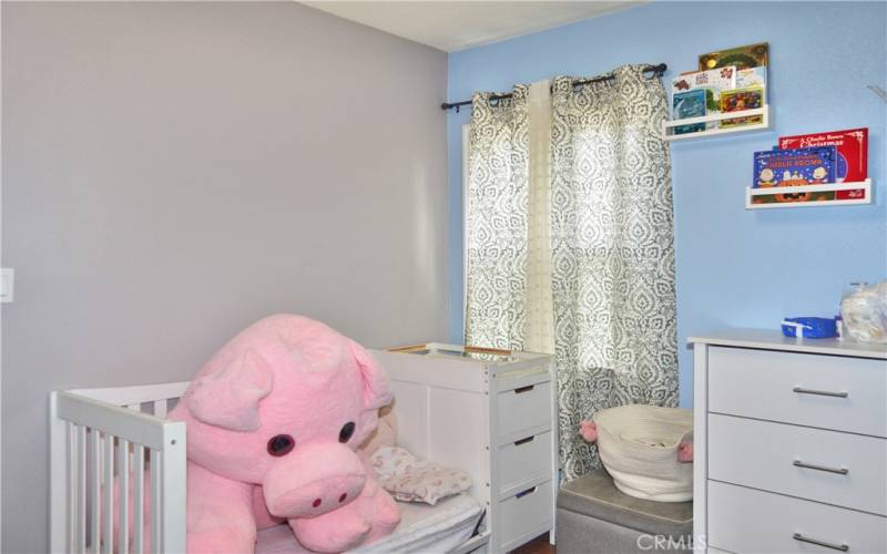 This darling 2nd bedroom offers more gorgeous wood laminate flooring, a modern ceiling fan, and views of the back patio.