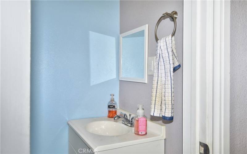 The half bath improvements made in the 2018 rehab include a modern vanity, porcelain tile flooring, raised panel door, and a new toilet.