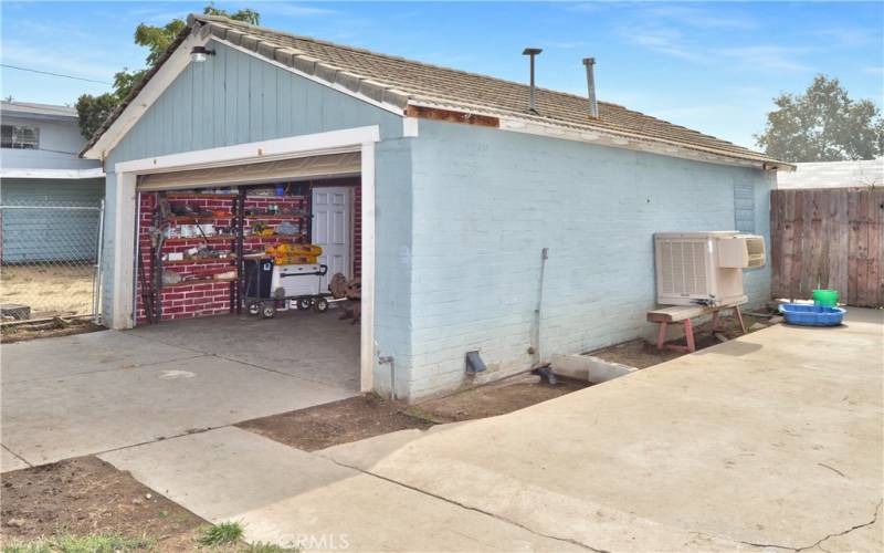 Here's a peek into the smaller of the 2 garages which offers 532 sq ft of space with faux brick paint and laundry hook-ups.