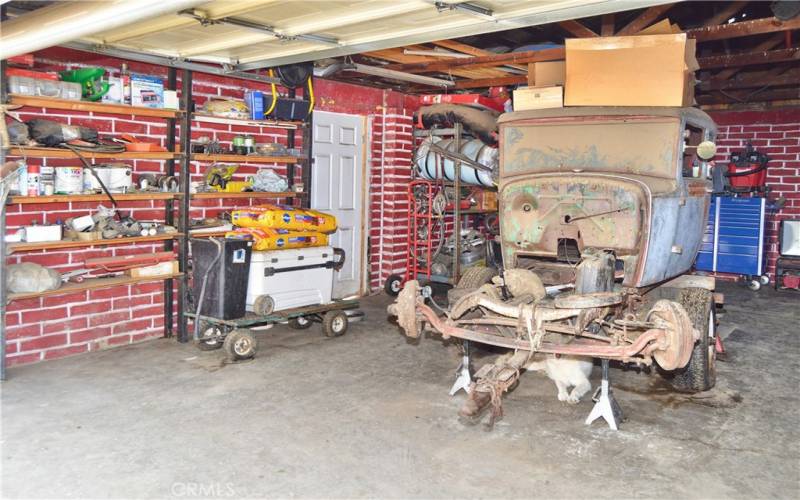 The smaller of the 2 garages which offers 532 sq ft of space with faux brick paint and laundry hook-ups. The side door leads to the separately-fenced dog run.