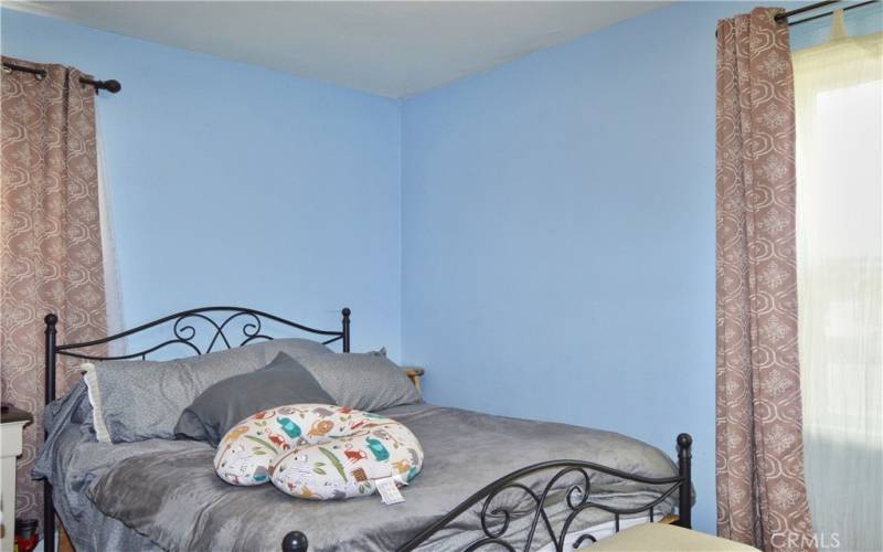 The primary bedroom looks out on the front yard and features more of that gorgeous wood laminate flooring and a modern ceiling fan light.