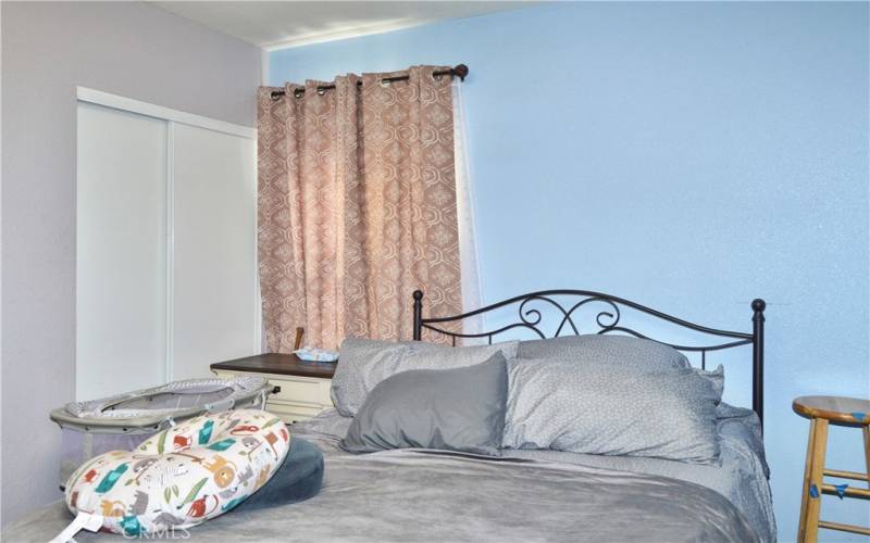 The primary bedroom looks out on the front yard and features more of that gorgeous wood laminate flooring and a modern ceiling fan light.