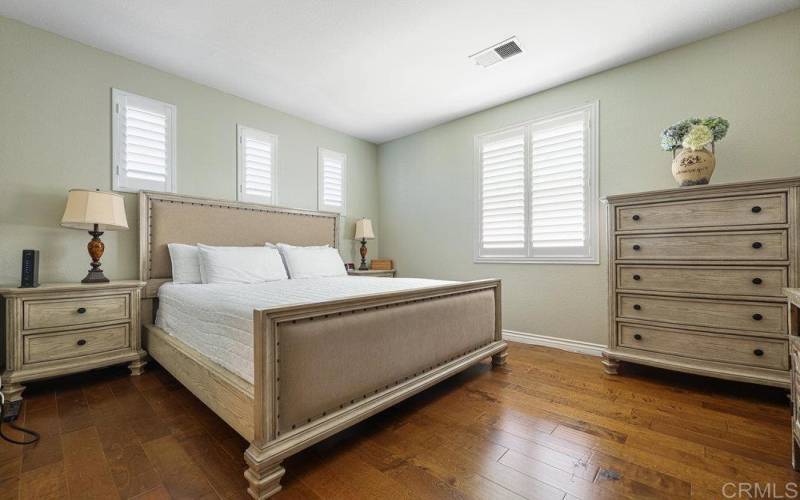 Inviting Large Bedroom witNatural light throughout, Custom Real Wood Flooring, Plantation Shutters.