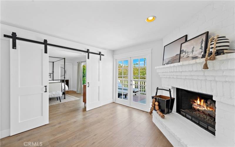 top of stairs features a unique fireplace and french doors leading to backyard balcony