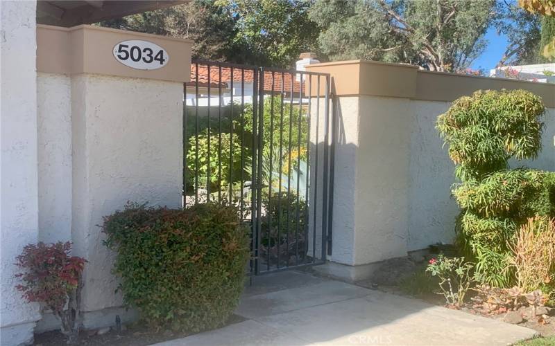 Wrought iron front gate opens to large tranquil courtyard.