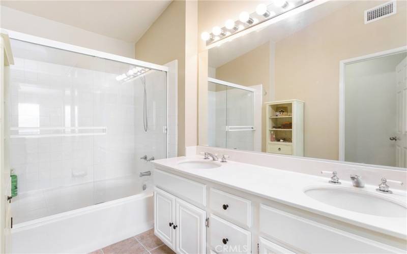 Ensuite primary bathroom has dual vanities and a shower tub combination