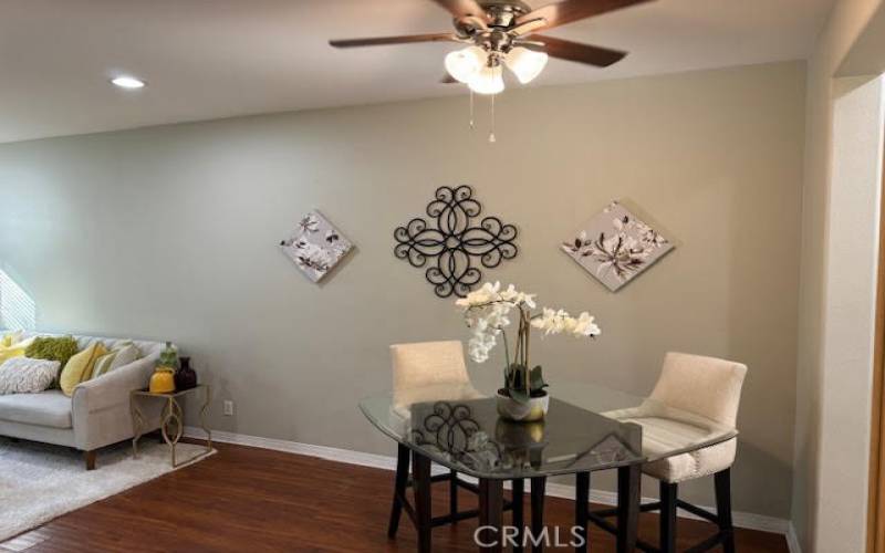 Dining area with ceiling fan adjacent to living room