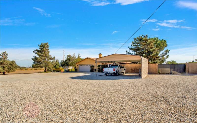 Front Driveway, Garage,additional covered parking area and Gated entrance to rear drive and to covered RV pad in rear.