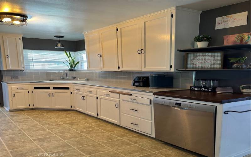 Kitchen is well designed with lots of cabinetry and tile counters and backsplash