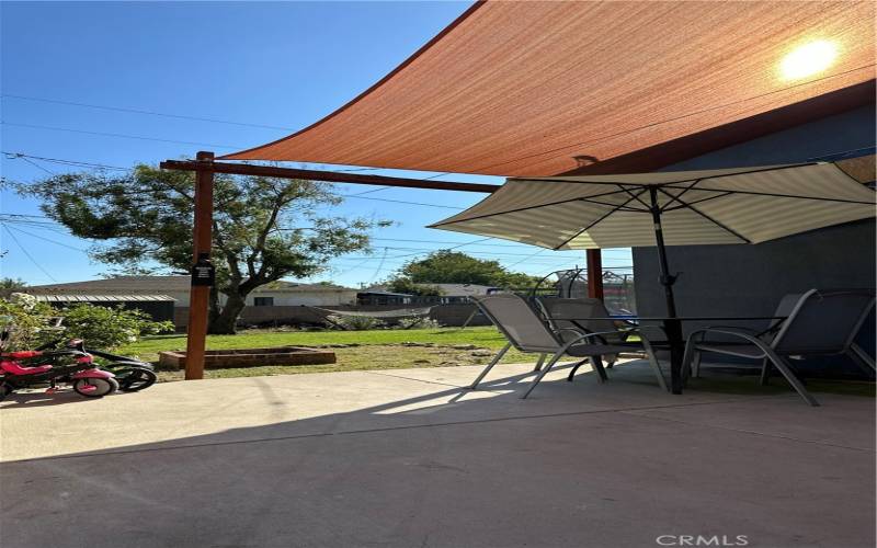 Check out this covered patio area overlooking the very nice sized backyard!