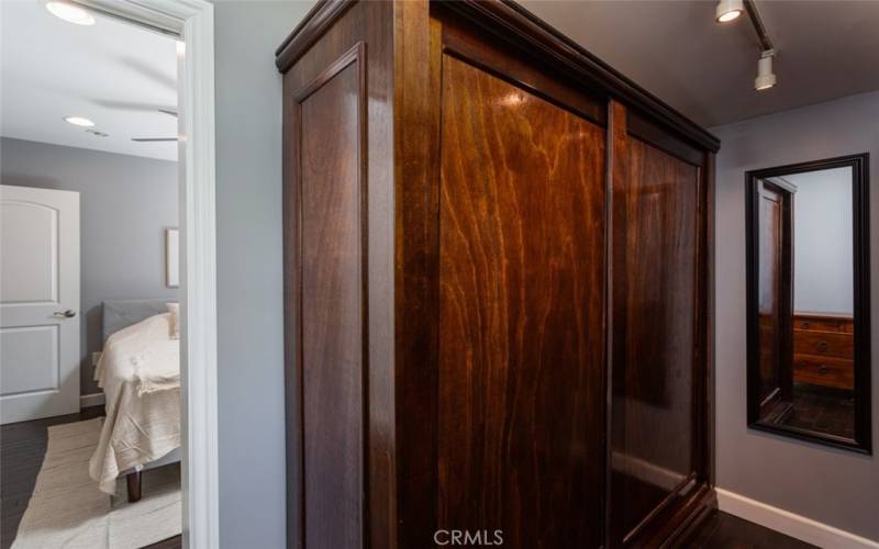 Primary bedroom walk in closet with wardrobes