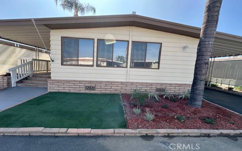 Front of Home with artificial grass, plants with drippers and auto sprinkler system.