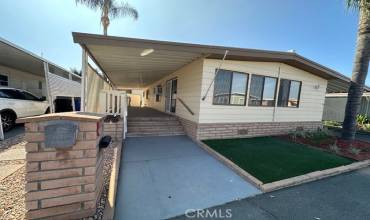 Front of Home with sealed cement walkway, privacy screening, block stairs and skirting.