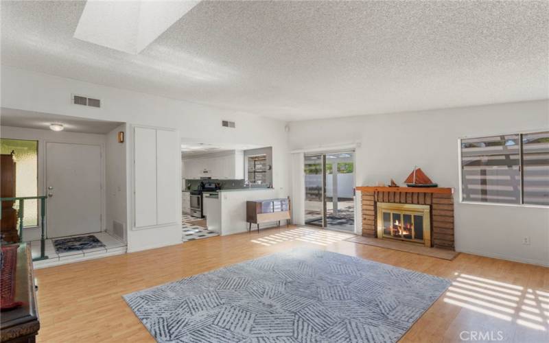 Large family room with fireplace and natural light, open to the kitchen and living room