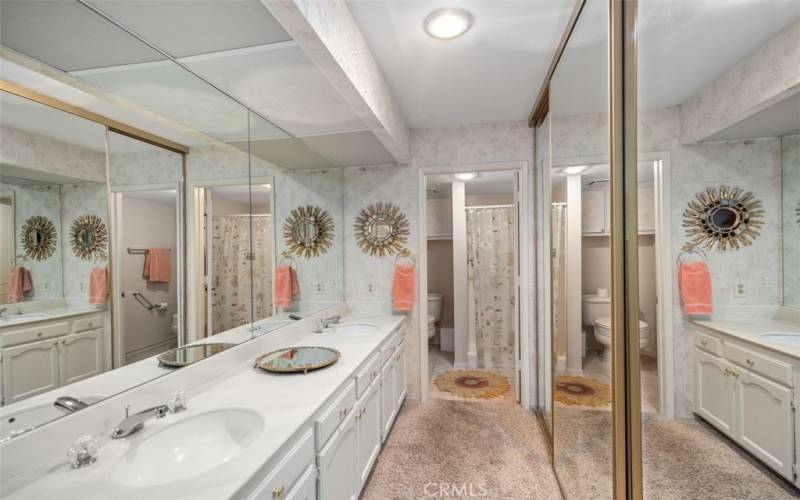 Primary bathroom includes his and hers sinks, large mirrored closet, and walk-in shower.