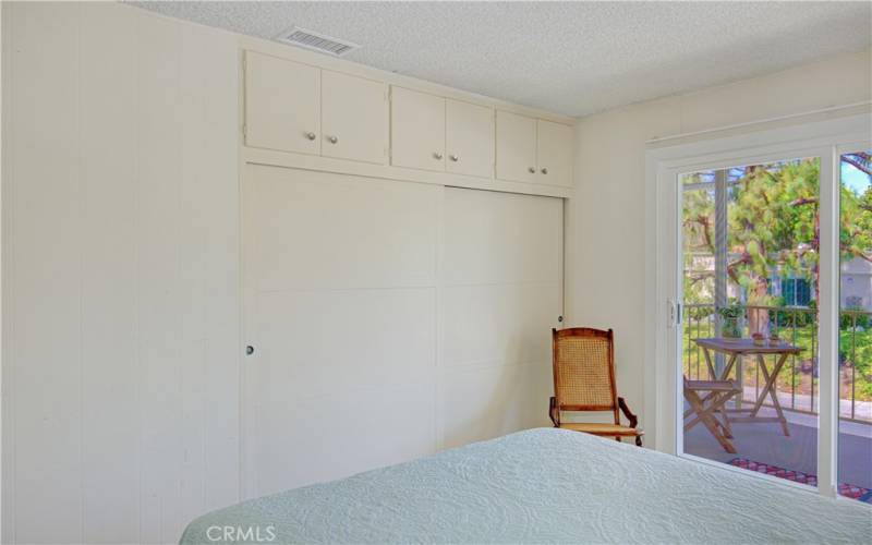 Large closet with storage cabinets above.