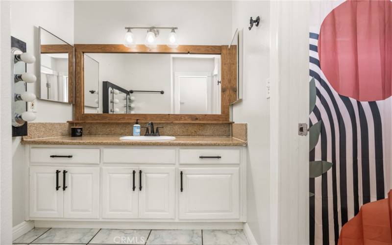 Spacious Bathroom with granite counters, huge mirror, and plenty of light!