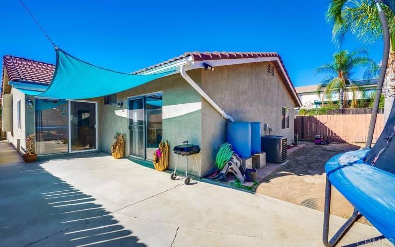 View down the side yard to the front yard; sliding doors to the open space area and MBR to the right