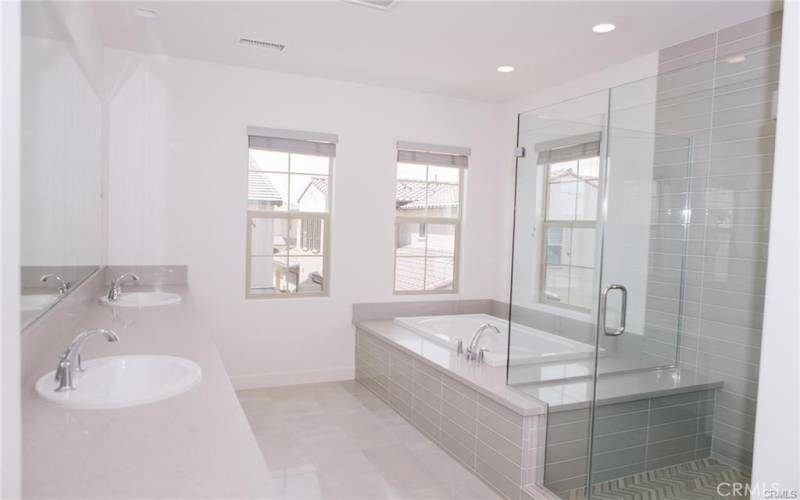 Primary bath has dual sinks, bathtub and shower.