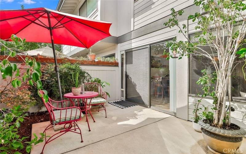 Patio with slider and windows looking into condo