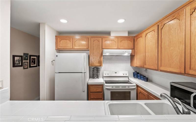 Another view of the kitchen with smooth scraped ceilings and recessed lighting.