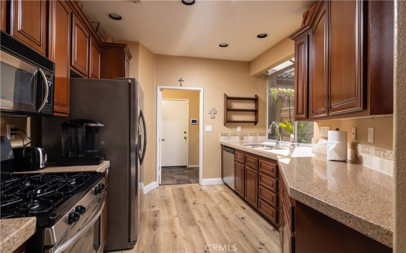 Kitchen showing plank flooring, granite counters and gas range. Recessed lights and lovely garden window.