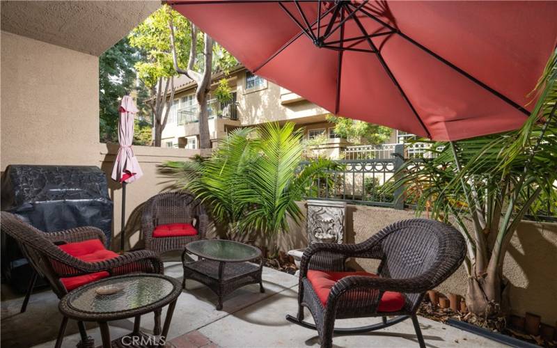 Cozy partially covered back patio for entertaining and room for BBQ cooking as well. Lush landscape by HOA and private garden beds create a serene atmosphere.