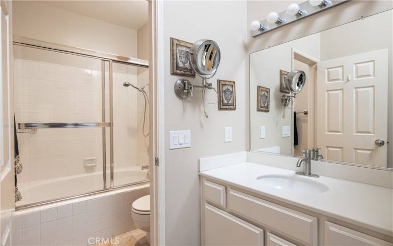 Tiled bathroom with tub & shower within Second bedroom suite.