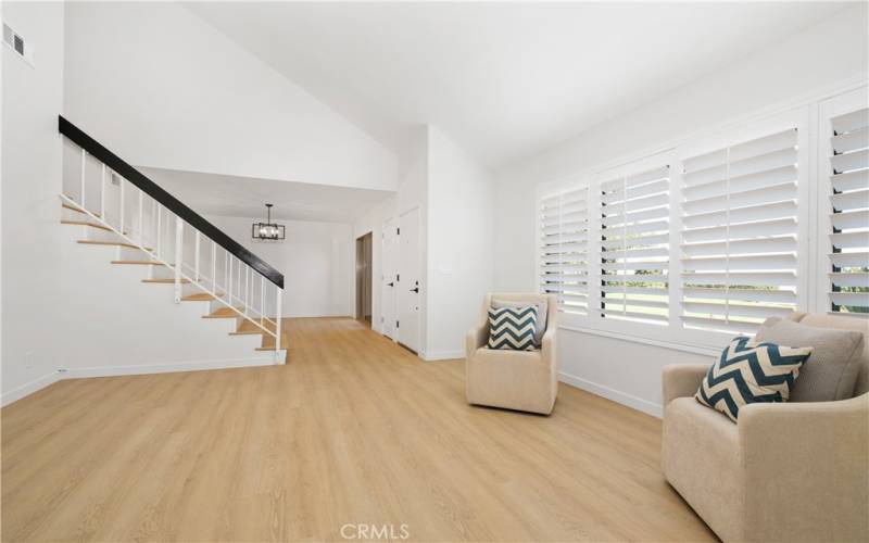 Another living room view showing front door and stairs