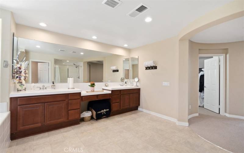 Primary bedroom walk-in closet located between primary bedroom and bathroom.