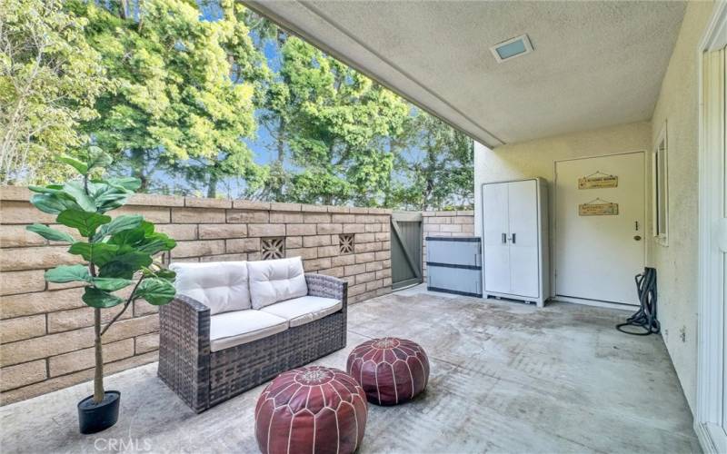 Peaceful ground level patio surrounded by green lawn and trees!