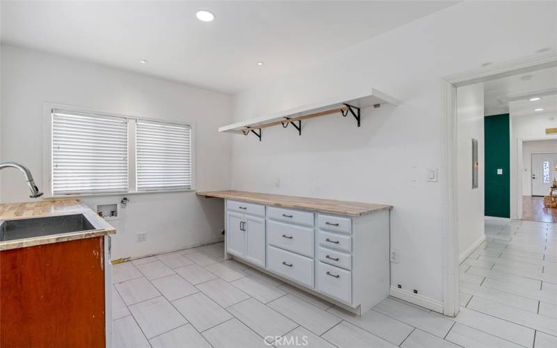 Another view of the laundry room with its own sink and plenty of storage.