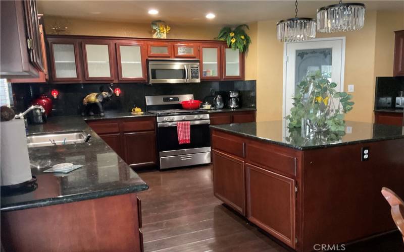 view of stainless still appliance with large island with storage, walking Pantry