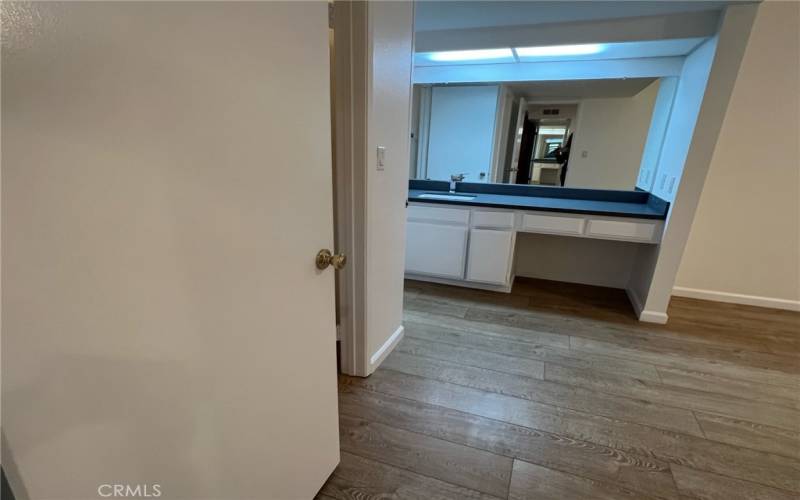 primary suite walk in closet vanity area & bathroom