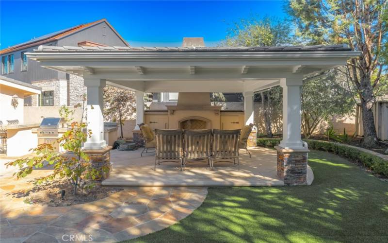 Inviting cabana with fireplace, covered seating, and storage . . .