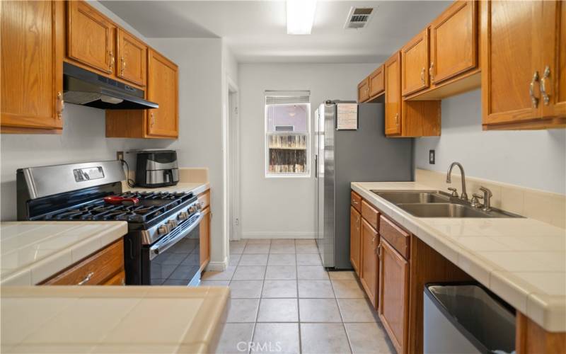 kitchen w/lots of cabinets, gas stove, vent hood. (No dishwasher)