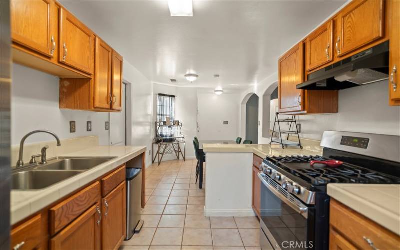 kitchen w/lots of cabinets, gas stove, vent hood. (No dishwasher)